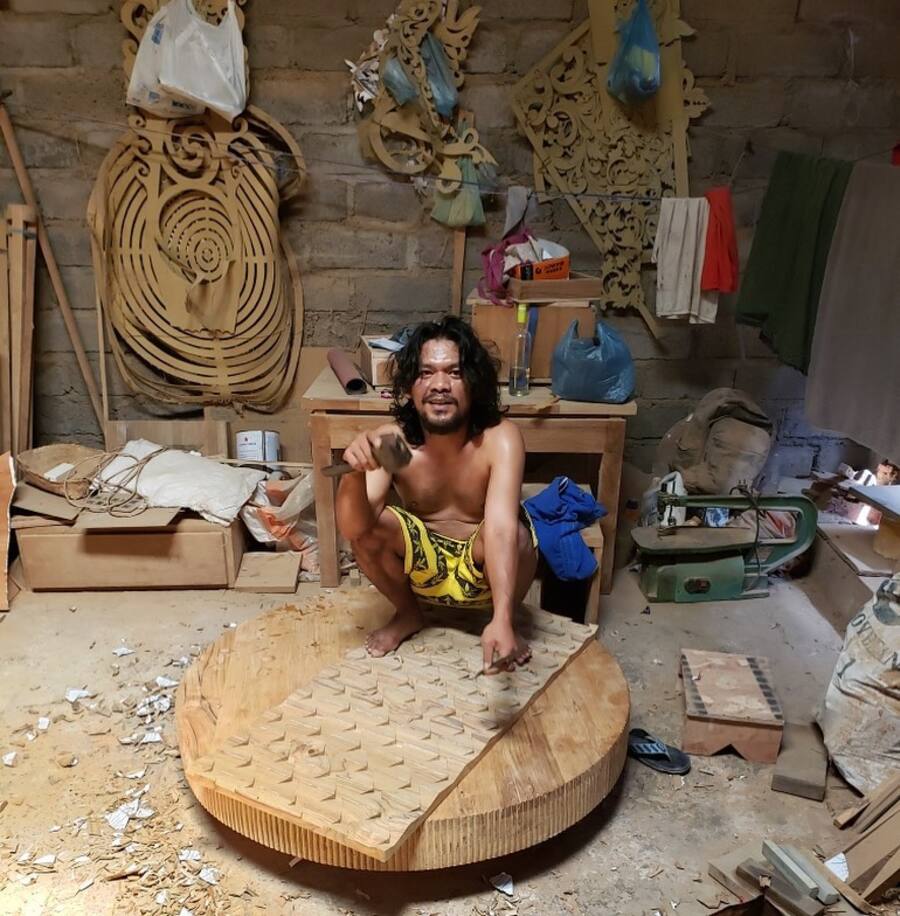 Artisan hand-carving a woven wood panel